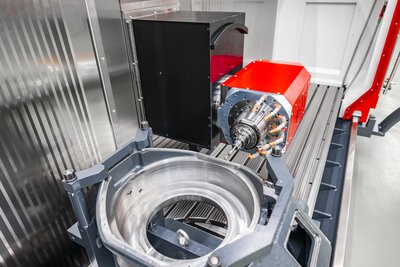 Pracovni prostor 5osoveho CNC obrabeciho centra TILTENTA 7-3600 NEO s obrobkem na NC otocnem stole a vykyvnym vretenem pri obrabeni