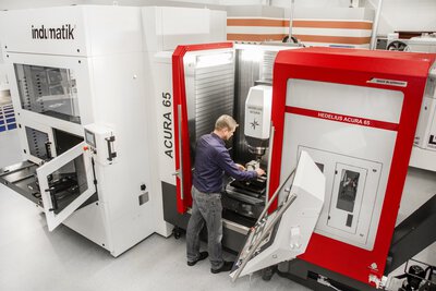 Palettenautomation indunorm Indumatik Light 120 - 5-Achs-Bearbeitungszentrum HEDELIUS ACURA 65 EL - Bediener am Maschineninnenraum