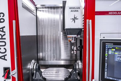 Area di lavoro del centro di lavorazione a 5 assi ACURA 65. L'utensile del magazzino utensili viene inserito nell'area di lavoro. Il mandrino principale è pronto a ricevere l'utensile.