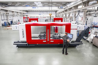 5-Achs-CNC-Bearbeitungszentrum TILTENTA 7-3600 NEO mit Schwenkspindel während der Bearbeitung und Bediener an der Steuerung