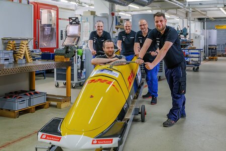 Das Team der Forschungswerkstatt Metall präsentiert stolz einen Wettkampf Viererbob des deutschen Verbandes