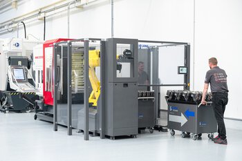 Werkstückautomation Lang RoboTrex - Bediener mit Werkstückwagen und Schraubstöcken