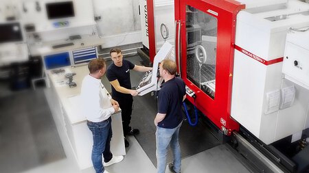 Il fornitore esterno di servizi dialoga con il responsabile di produzione e l'utente dello stabilimento del cliente. Lavorazione in corso sul centro di lavoro a 5 assi TILTENTA 7-2600 NEO.
